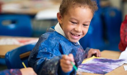 Boy wearing a apron painting